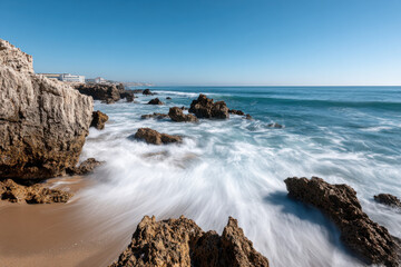 Motion blur of waves crashing against the rocks on the shore