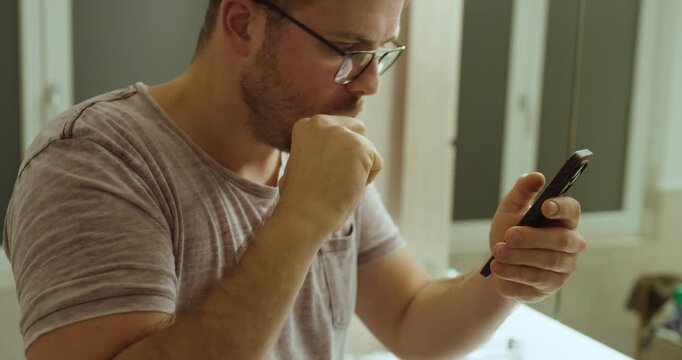 A man brushes his teeth while watching his phone, symbolizing social media addiction and constant smartphone use in daily routines.