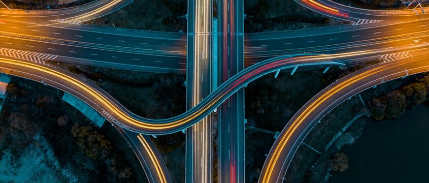 Nocturnal highway interchange with glowing teal loops