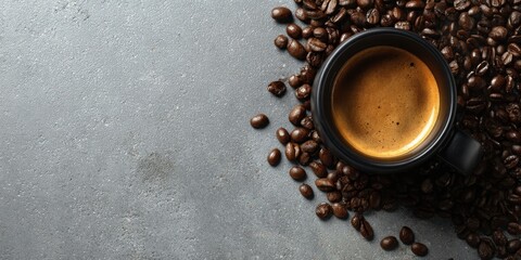The coffee cup surrounded by roasted beans on textured gray background
