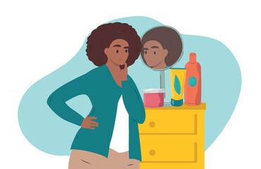 A woman looks in the mirror with displeasure while choosing cosmetics