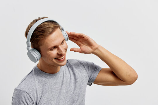 happy young man with headphones enjoy music smiling casual gray t-shirt isolated white background digital detox mental health concept