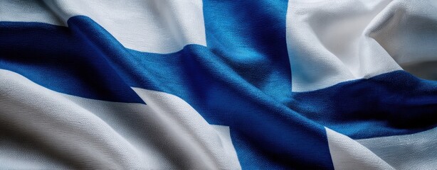 The Finnish flag waving in close-up showing textured blue cross on white