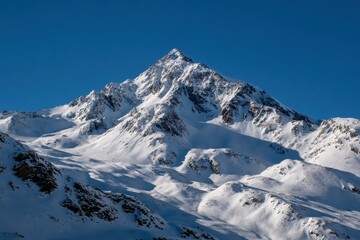 Majestic snow-capped mountain peak under a clear blue sky