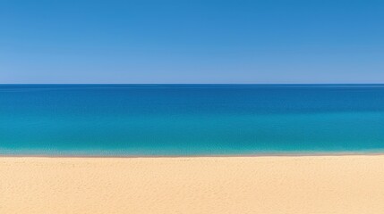 A beach with clear blue water and light tan sand.