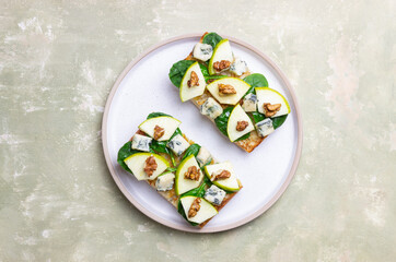 Bruschetta with spinach, honey, blue cheese, pear, and nuts. Healthy eating. Vegetarian food.