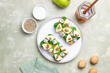 Bruschetta with spinach, honey, blue cheese, pear, and nuts. Healthy eating. Vegetarian food.
