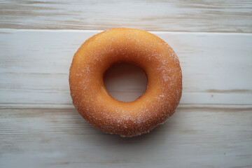 Top View of Sugared Cruller Donut Ring on Light Wooden Surface