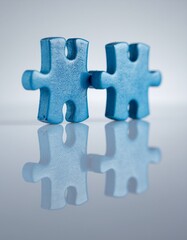 Fototapeta premium Two 3D blue puzzle pieces interlocking, symbolizing effective teamwork, collaboration, and partnership in business.