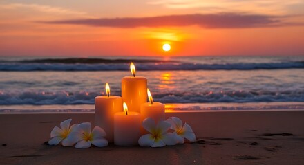 Candles and flowers on beach at sunset with ocean waves