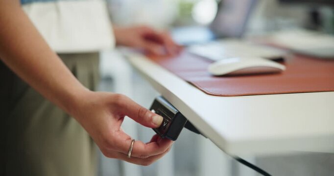 Button, hand and woman adjust standing desk in office to regulate height for user comfort. Control, raise and press with employee person in workplace for optimization, position change or posture