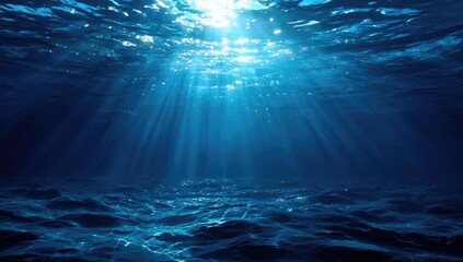 Sunbeams pierce a deep, dark blue ocean, illuminating particles and subtly textured seabed.  A serene, underwater scene