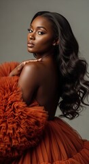 Woman wearing a vibrant orange fluffy dress, radiating elegance and style.
