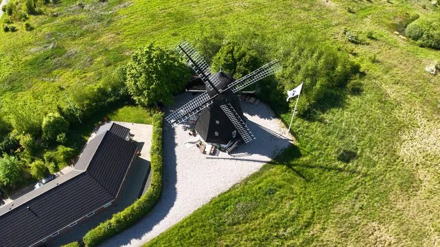 Aerial drone footage of Eg&aring; Mill in Denmark, showing the historic windmill surrounded by green fields and countryside in bright daylight