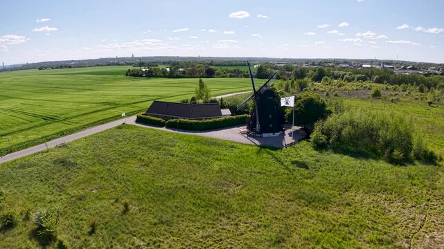 Aerial drone footage of Ega Mill in Denmark surrounded by green farmland and open countryside under a bright summer sky