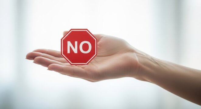 Woman holding red stop sign with no text. Concept of rejection, boundary setting, and refusal. Visual metaphor for saying no.