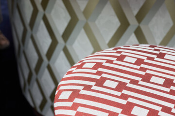 Closeup of geometric fabric on sleek ottoman in stylish room