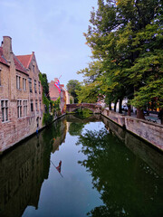 Fototapeta premium Still Water and Tree Lined Banks of a Historic Canal in Bruges