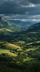 Verdant valley nestled between dramatic, dark-shadowed mountains under a brooding sky; sunlight illuminates rolling hills and scattered farmhouses