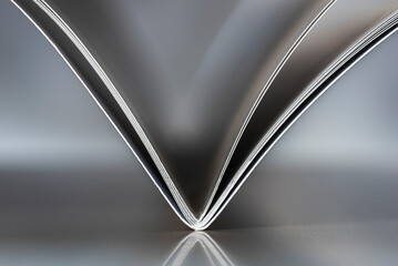 Minimalist close-up of an open notebook forming geometric lines on a uniform background