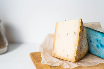 Fresh farm products. A piece of blue and yellow, fresh, aged, natural farm cheese with lavender and nuts on a wooden board.
