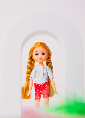 Brightly colored doll standing inside a playful arch, showcasing a cheerful expression and braided hair