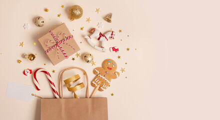 Christmas shopping concept composition with paper bag and various small gifts on light background with copy space