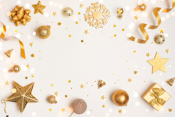 Christmas decoration gold color objects on light background with holiday ornament and copy space in center