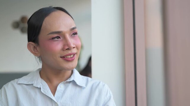 Thai transgender person in coffee shop smiling and thinking close-up portrait