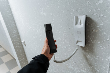 preparing tool by plugging into socket, systematic connection of remote to electrical outlet in hallway, deliberate action of positioning remote connector into hallway socket for operation
