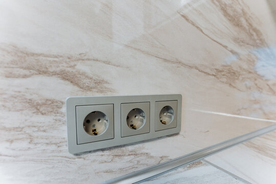sleek outlets with reflective surfaces, luxury design featuring integrated power sources and polished finishes, modern marble backsplash with concealed outlets and sophisticated accents - Powered by Adobe