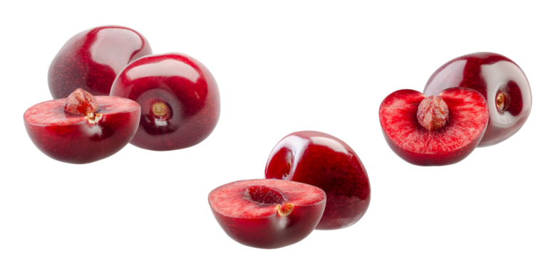 arrangement of whole and halved ripe dark red cherries clustered together, featuring the inner flesh and small pits, isolated on black.