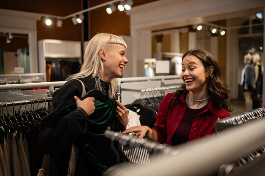 Women friends laughing shopping for clothes together - Powered by Adobe