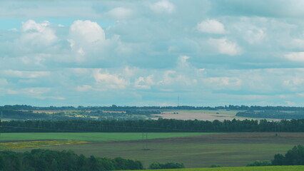 A breathtaking and scenic landscape featuring rolling fields and a beautifully cloudy sky