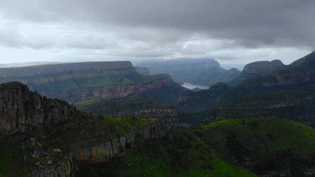 layered terraces and ridges, misty conditions conceal stratified ridges and fissured mountain terrain