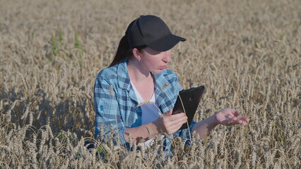 A woman in a field uses a tablet for insights on agricultural practices and information
