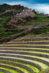 P&iacute;sac, Pisac, Sacred Valley, Cusco, Peru: vertical view of the ancient Inca citadel rising above concentric agricultural terraces under a dramatic Andean sky. Geometry and heritage in harmony.