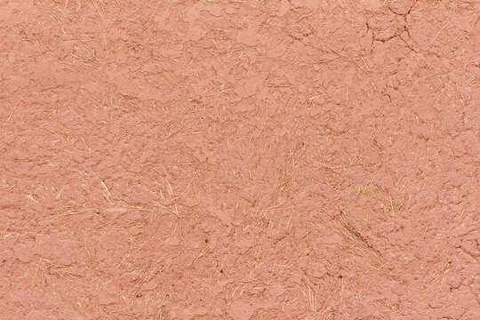 Traditional adobe wall texture made of clay and straw in natural light, Pisac, P&iacute;sac, Sacred Valley, Cusco, Peru. Rustic earthen material background for architecture and design.