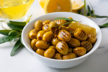 Grilled green olives. Tasty organic green olives in the plate.