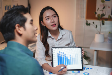 Business colleagues discussing data analysis during late meeting
