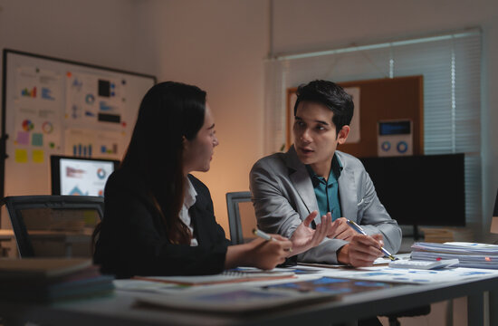 Business colleagues collaborating on project, working late in office