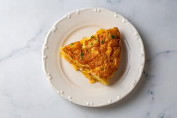 Spanish omelette with potatoes, typical spanish cuisine on gray concrete floor. Tortilla Espanola. Turkish name; Yumurtali patates