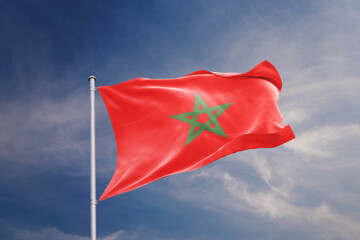 Morocco flag waving in the wind on blue sky background.