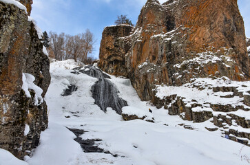 frozen Jermuk waterfall and red rocks of Arpa river canyon (Vayots Dzor, Armenia)