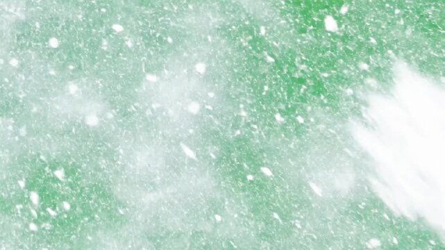 White snowflakes falling on a green screen background with a large snowflake in the center area