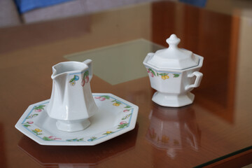 Charming antique china collection arranged on polished surface illuminated by soft indoor lights