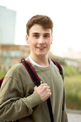 Smiling student walking with backpack on campus