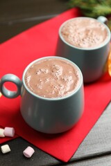Tasty hot cocoa and marshmallows on black wooden table, closeup. Christmas season
