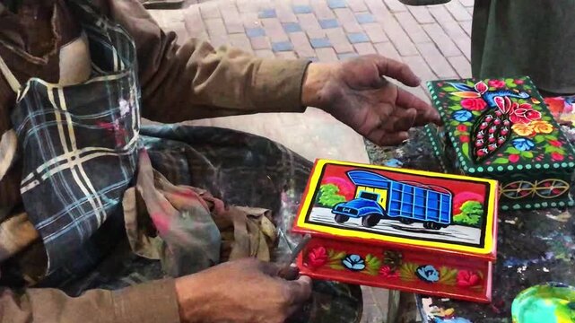 Close-Up of Artist Painting Traditional Colorful Truck Art Design on a Small Handicraft Item
