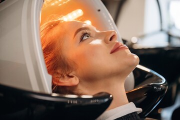 Yellow color. Woman is in a beauty salon with LED hair growth helmet